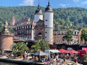 un grupo de personas sentadas en una playa frente a un edificio en Pension Jeske Heidelberg, en Heidelberg