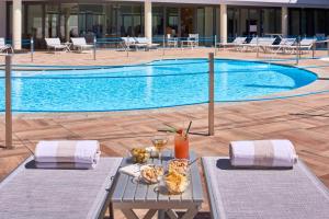 una piscina con dos mesas con comida. en UNAHOTELS Varese, en Varese