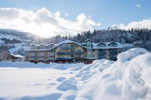 ein großes Gebäude mit Schnee vor der Tür in der Unterkunft Alpinhotel Maistatt in Schladming