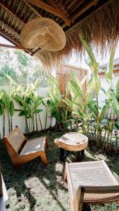 a patio with chairs and a table and a umbrella at petra bianca uluwatu in Uluwatu