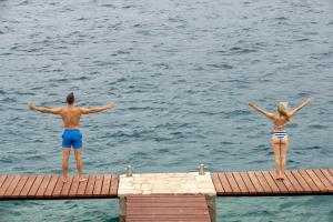 two people standing on a dock in the water at TUI BLUE Kalamota Island - Adults Only in Dubrovnik