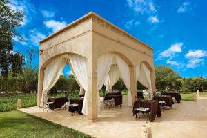 a gazebo with tables and chairs under it at Atlas Widan in Marrakech