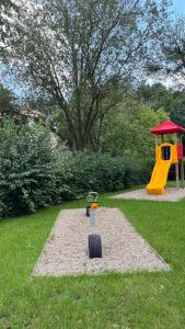 um parque infantil com um escorrega amarelo na relva em Schöne 3-Zimmer Erdgeschosswohnung am Bergpark,Unesco,Therme,Train, Wilhelmshöher Allee 329 em Kassel