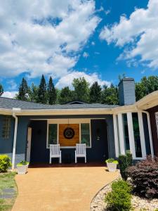 una casa con due sedie bianche sul portico anteriore di Sonsak - Unit 2 a Charlottesville