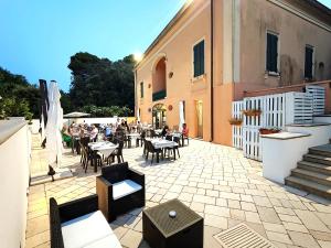 un patio avec des tables et des chaises et un bâtiment dans l'établissement B&B Luxury da Salvatore, à Presicce