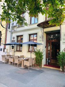 a table with chairs and an umbrella in front of a building at Villa & Restaurant Levoslav House in Sibiu