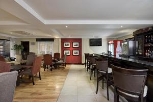 un ristorante con bar, tavoli e sedie di Protea Hotel by Marriott Mahikeng a Mahikeng