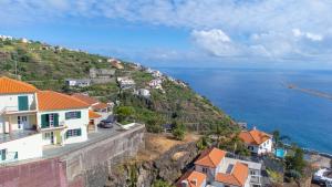 a view of a hill with houses and the ocean at Casa Vista Mar by GALMI in Calheta