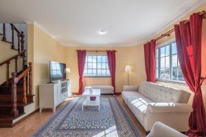 a living room with a couch and a tv at Casa Vista Mar by GALMI in Calheta