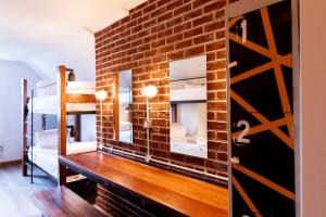 a room with a brick wall and a wooden table at The Nest Boutique Hostel in Galway