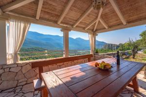 uma mesa de madeira com uma tigela de bananas e uma garrafa de vinho em Villa Luce em Omiš