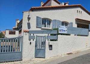 un edificio bianco con un cancello e un cartello sopra di Villa Farniente a Sète