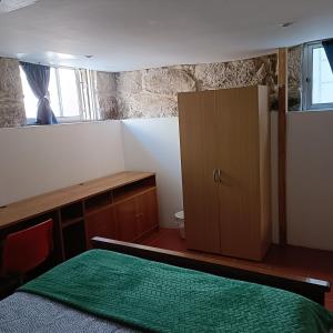 a bedroom with a bed and a cabinet and a window at Guesthouse Monsanto in Porto