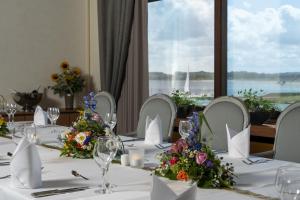 een eetkamer met een tafel met bloemen erop bij Maritim Strandhotel Travemünde in Travemünde