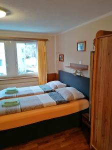 a bedroom with a bed with a blue headboard and a window at Hotel Stille in St. Moritz