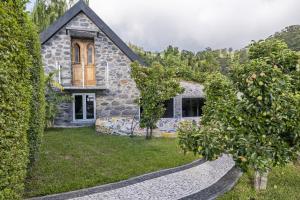 een stenen huis met bomen ervoor bij Casas Maravilha by Madeira Sun Travel in Calheta