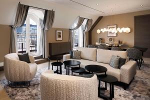 a living room with a couch and chairs and tables at Hilton Vienna Plaza in Vienna