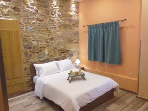 a bedroom with a bed and a stone wall at CityZen Rooms Chios in Chios