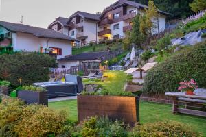 Blick auf einen Garten mit Häusern im Hintergrund in der Unterkunft Hotel Ciamp in St. Christina in Gröden