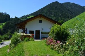 カンポ・ディ・トレンスにあるMartlerhof Urlaub auf dem Bauernhofの緑の丘を背景にした家