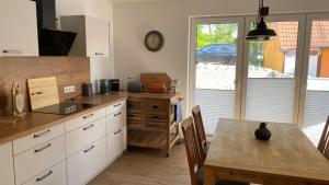 a kitchen with a table and a clock on the wall at Klönhüsing in Altefähr