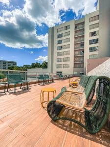 una terraza con bancos y mesas en un edificio en Equilibrio Park Veredas Flat- Rio Quente Goiás, en Rio Quente