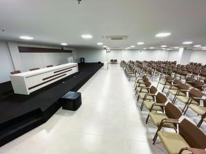 una sala de conferencias vacía con filas de sillas y un podio en Equilibrio Park Veredas Flat- Rio Quente Goiás, en Rio Quente