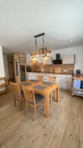 a kitchen with a wooden table and chairs in a room at Klönhüsing in Altefähr