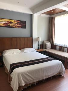 sypialnia z dużym łóżkiem i kanapą w obiekcie Celosia Chiang Mai Hotel w mieście Chiang Mai