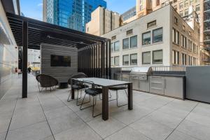 eine Terrasse mit einem Tisch und Stühlen auf einem Gebäude in der Unterkunft Fully Furnished Apt Near Millenium Park- 29 in Chicago