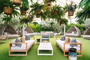 un patio con sillas, mesas y plantas en Nautilus Sonesta Miami Beach, en Miami Beach