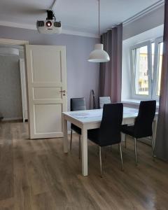 uma sala de jantar com uma mesa branca e cadeiras em The entire comfortable apartment em Rakvere