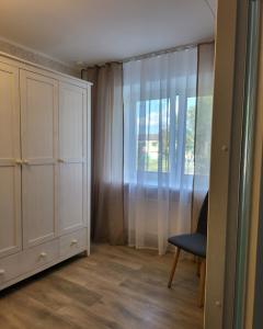 um quarto com um armário, uma cadeira e uma janela em The entire comfortable apartment em Rakvere