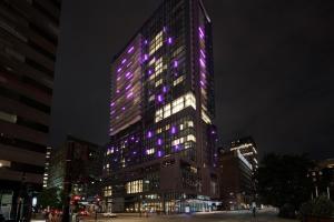 un edificio alto con luci viola di HONEYROSE Hotel, Montreal, a Tribute Portfolio Hotel a Montréal