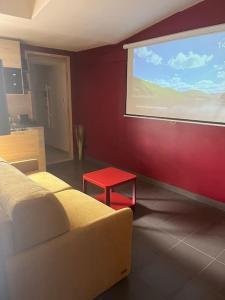 Zimmer mit einer großen Leinwand und einem roten Tisch in der Unterkunft Suite avec Sauna 36m² in Niort