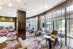 une salle d'attente avec des chaises, des tables et des fenêtres dans l'établissement Courtyard by Marriott Boston Waltham, à Waltham