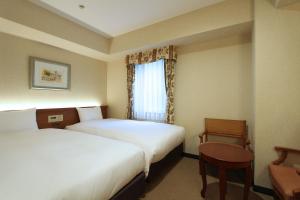 a hotel room with two beds and a window at KOKO HOTEL Nagoya Sakae in Nagoya