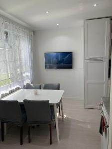 a dining room with a white table and chairs at Rum i lyxig lägenhet nära Emporia in Malmö