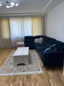 a living room with a blue couch and a table at Rum i lyxig lägenhet nära Emporia in Malmö