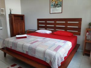 een slaapkamer met een bed met een rode en witte deken bij rumah566 in Yogyakarta