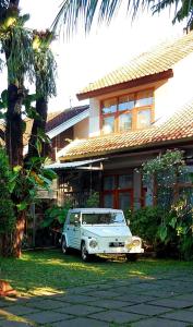 een oude witte auto geparkeerd voor een huis bij rumah566 in Yogyakarta