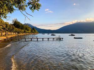 un lac avec un quai et des bateaux dans l'eau dans l'établissement Cabane pour vos vacances à 190m du lac d’Annecy, à Menthon-Saint-Bernard