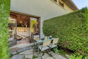 une terrasse avec une table et des chaises devant un bâtiment dans l'établissement Cabane pour vos vacances à 190m du lac d’Annecy, à Menthon-Saint-Bernard