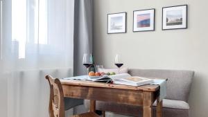 a wooden table with a glass of wine on it at Apartments am Dom in Naumburg