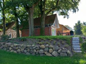 een huis met een stenen muur voor een huis bij Ferienhaus Heidenest, E-Bike, Bettwäsche und Handtücher zubuchbar in Buchholz in der Nordheide