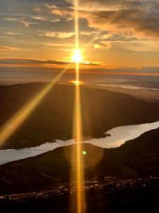 an image of the sun setting over a body of water at Snowdonia Retreat in Bangor