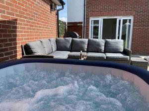 a large hot tub in a backyard with a couch at Snowdonia Retreat in Bangor