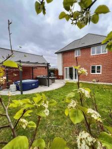 a red brick house with a yard with white flowers at Snowdonia Retreat in Bangor