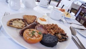 un piatto di prodotti per la colazione su un tavolo di Poolewe Hotel a Poolewe