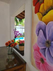 uma pintura de flores numa parede ao lado de um espelho em Hermosa casa en Cuernavaca cerca de los mejores restaurantes y plazas em Cuernavaca